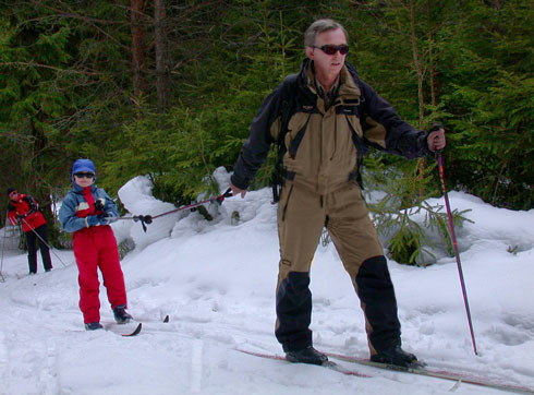 Сын катается на лыжах и папе