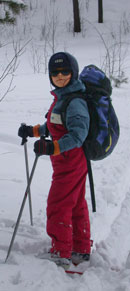 Восьмилетний лыжник на загородной прогулке на лыжах