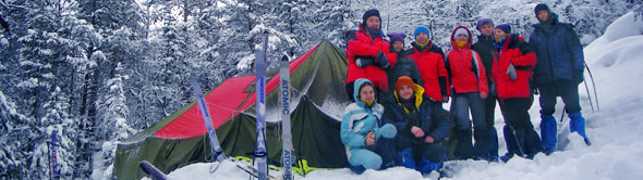 Туристы лыжники у таежной палатки